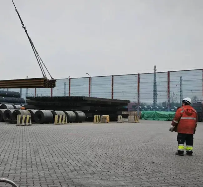 H beam structural steel sections being lifted by crane at an industrial steel yard